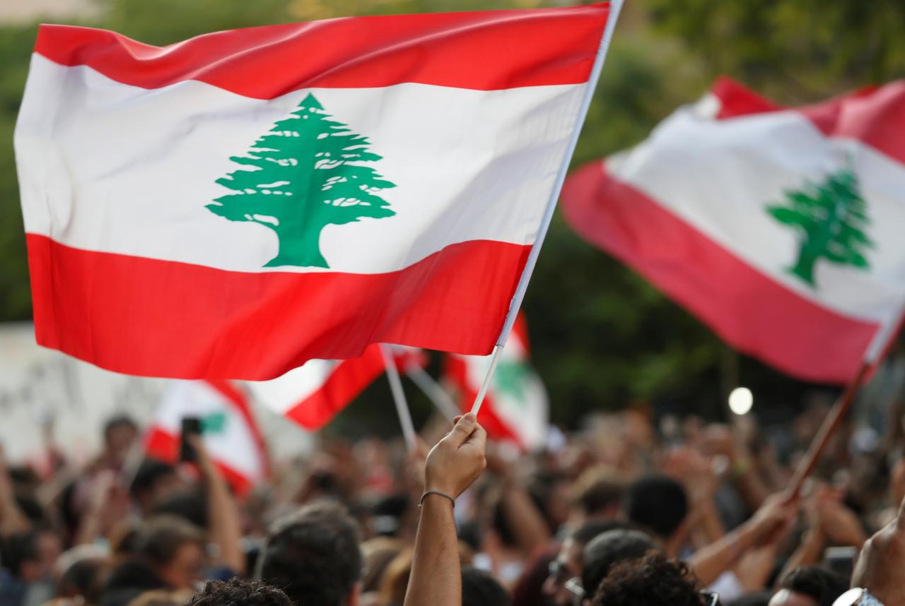 FILE PHOTO: Demonstrators wave Lebanese flags during a protest in Beirut, Lebanon, October 31, 2019. REUTERS/Goran Tomasevic/File Photo